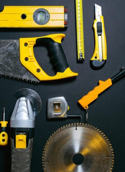 A collection of yellow and black construction tools arranged on a dark flat surface, ideal for DIY projects.
