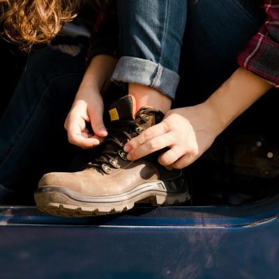 Woman Tying a Shoelace in Work Boots